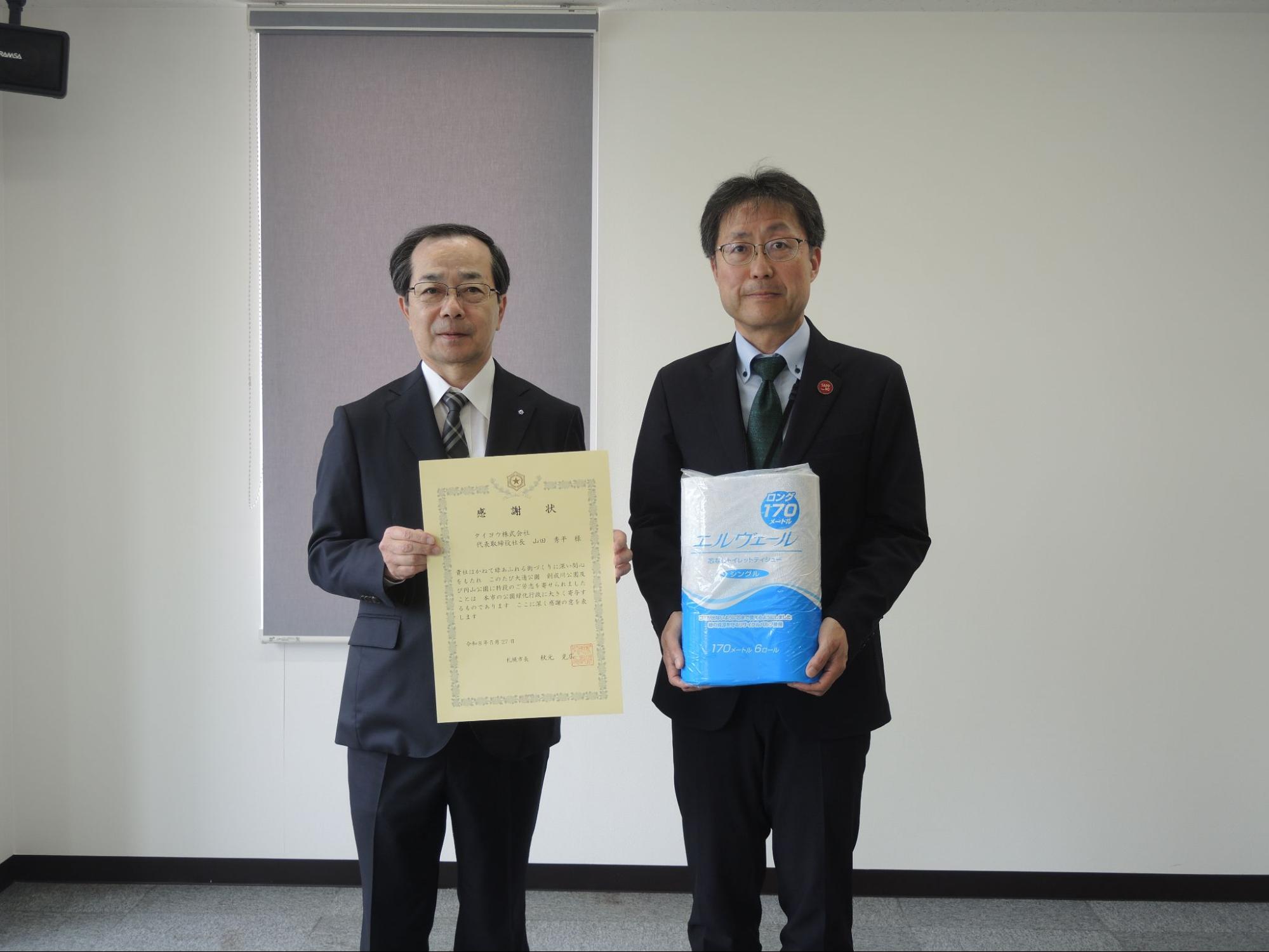 感謝状を持つ山田社長㊧と市建設局みどりの推進部の石橋部長
