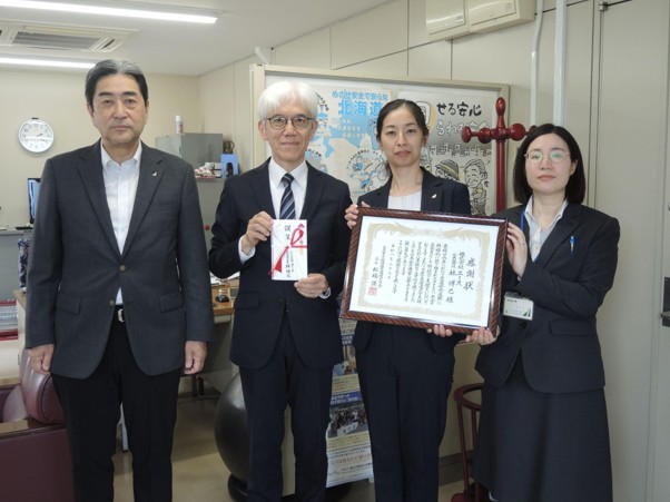 感謝状を持つ林社長（右から2人目）と遺児の会の吉田専務（左隣）ら