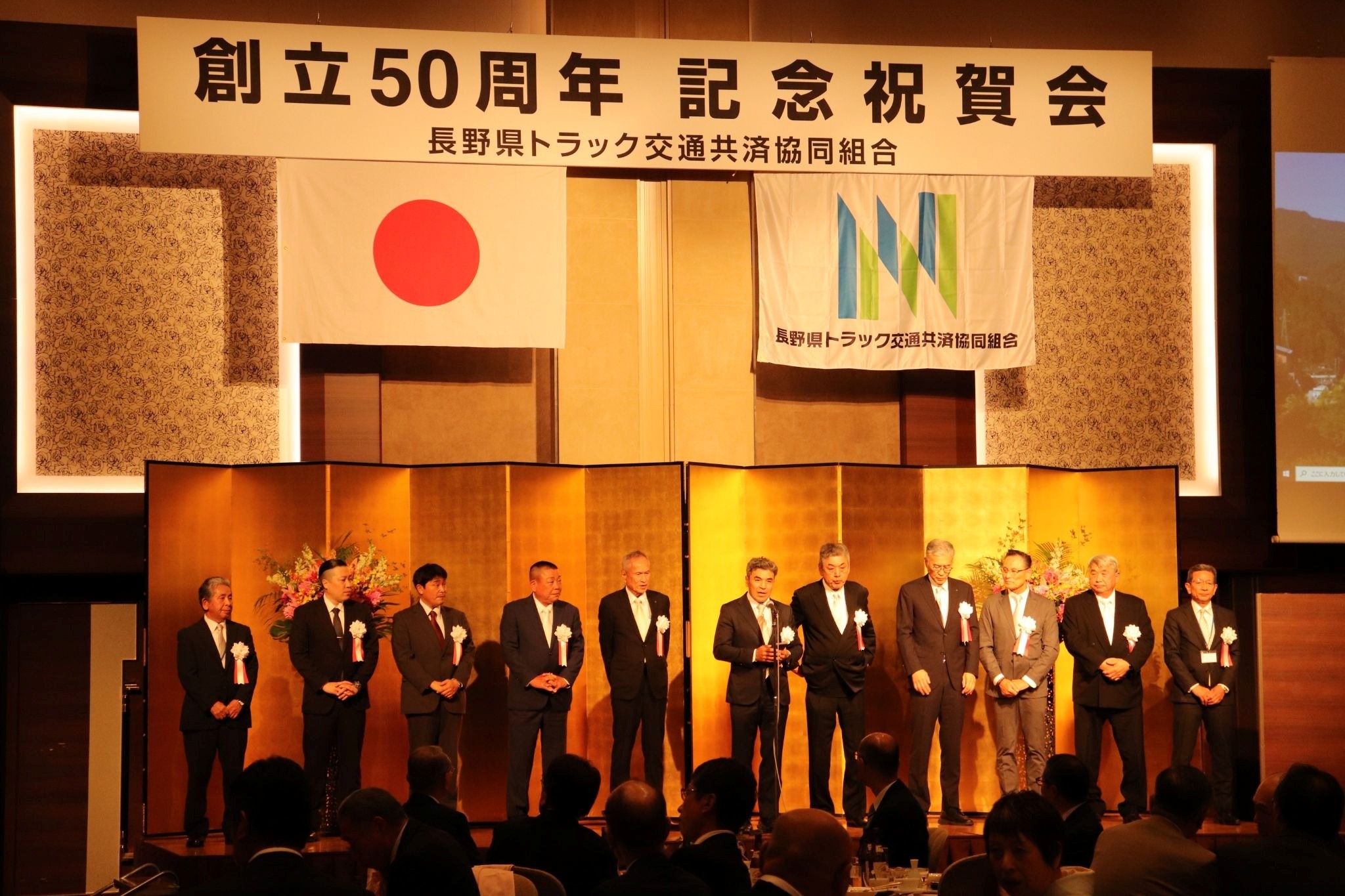 完成した組合旗を掲げ、事業の充実と発展を誓い合う