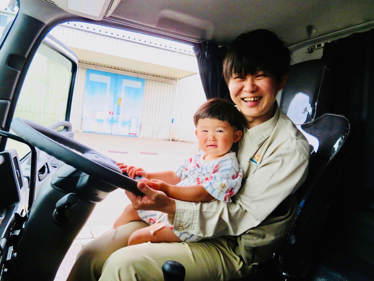 社員と一緒にトラックに試乗する子ども
