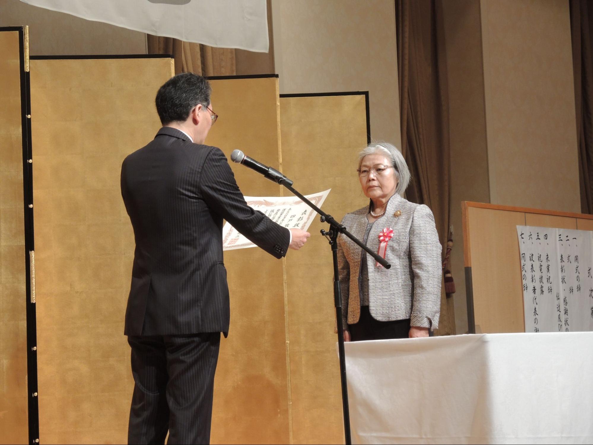 井上局長㊧から表彰状を受け取るひまわりの四戸氏