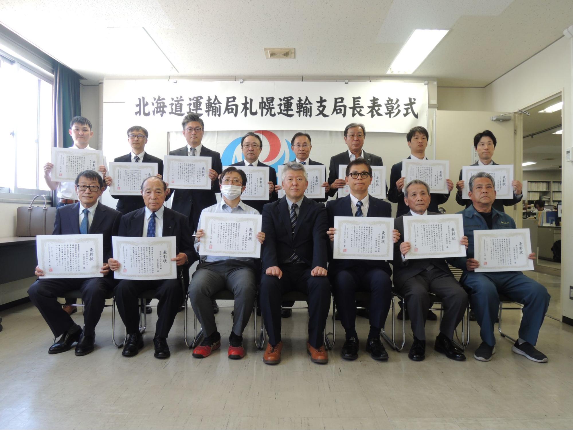 記念撮影に臨む久原支局長（前列中央）ら