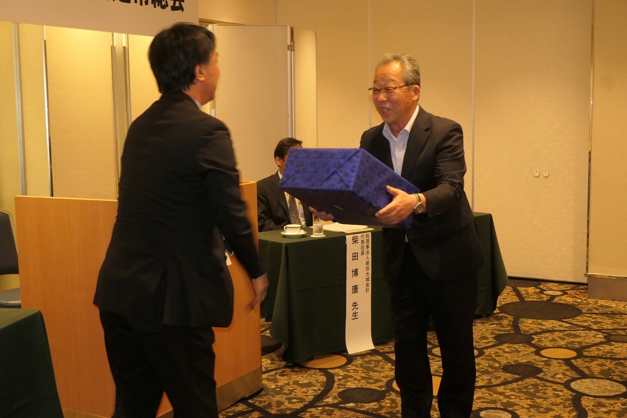 商工中金松本支店の小島支店長㊧から記念品を受け取る丸山理事長