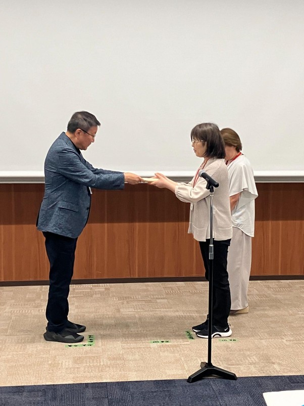 樋口社長㊧から表彰状を受け取るサークルKF4のメンバー