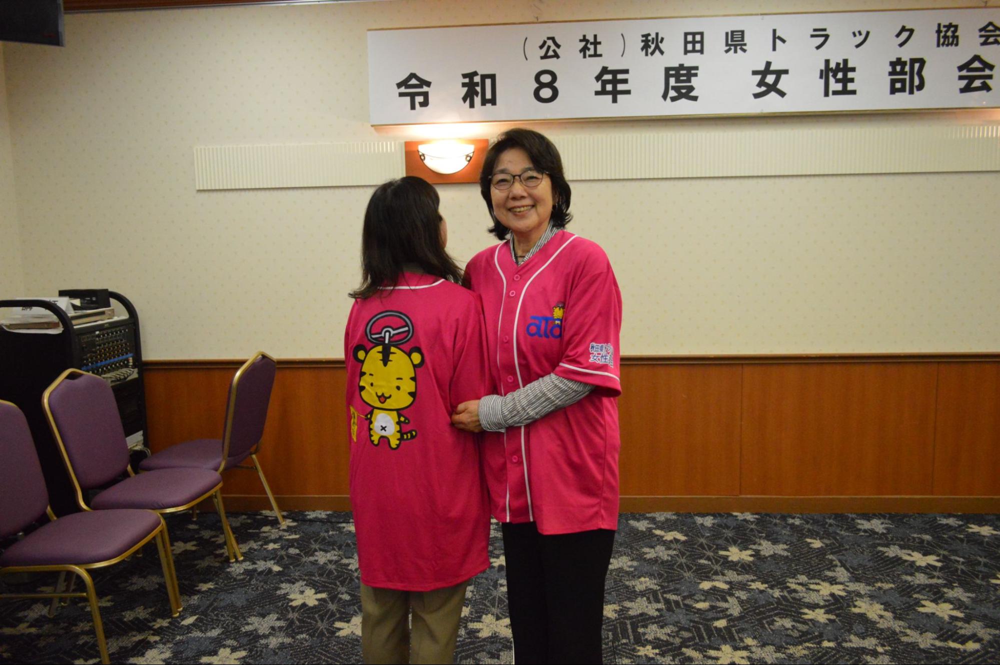 オリジナルシャツを試着する嵯峨部会長㊨