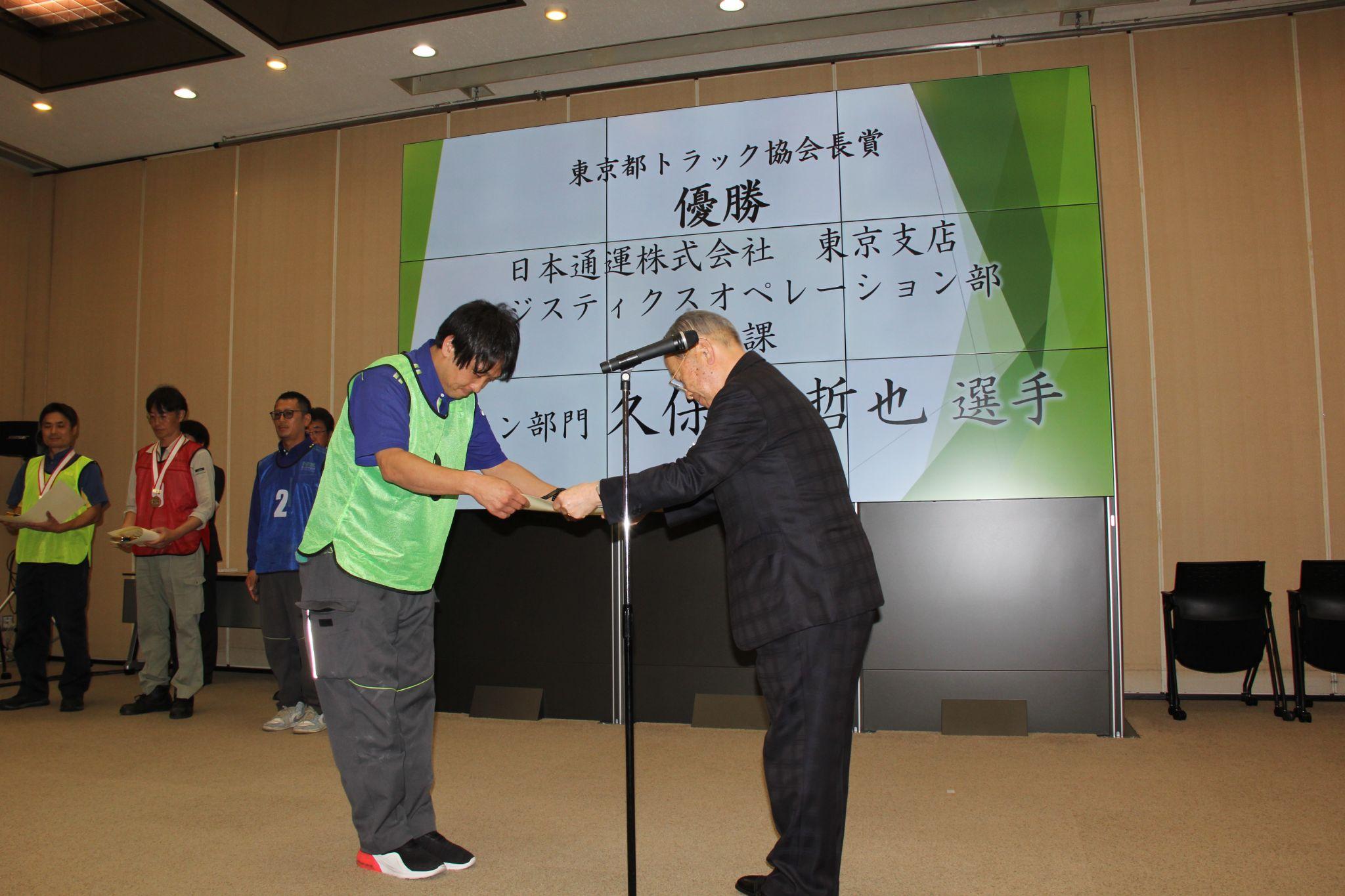 久保寺選手㊧に賞状などを手渡す水野会長