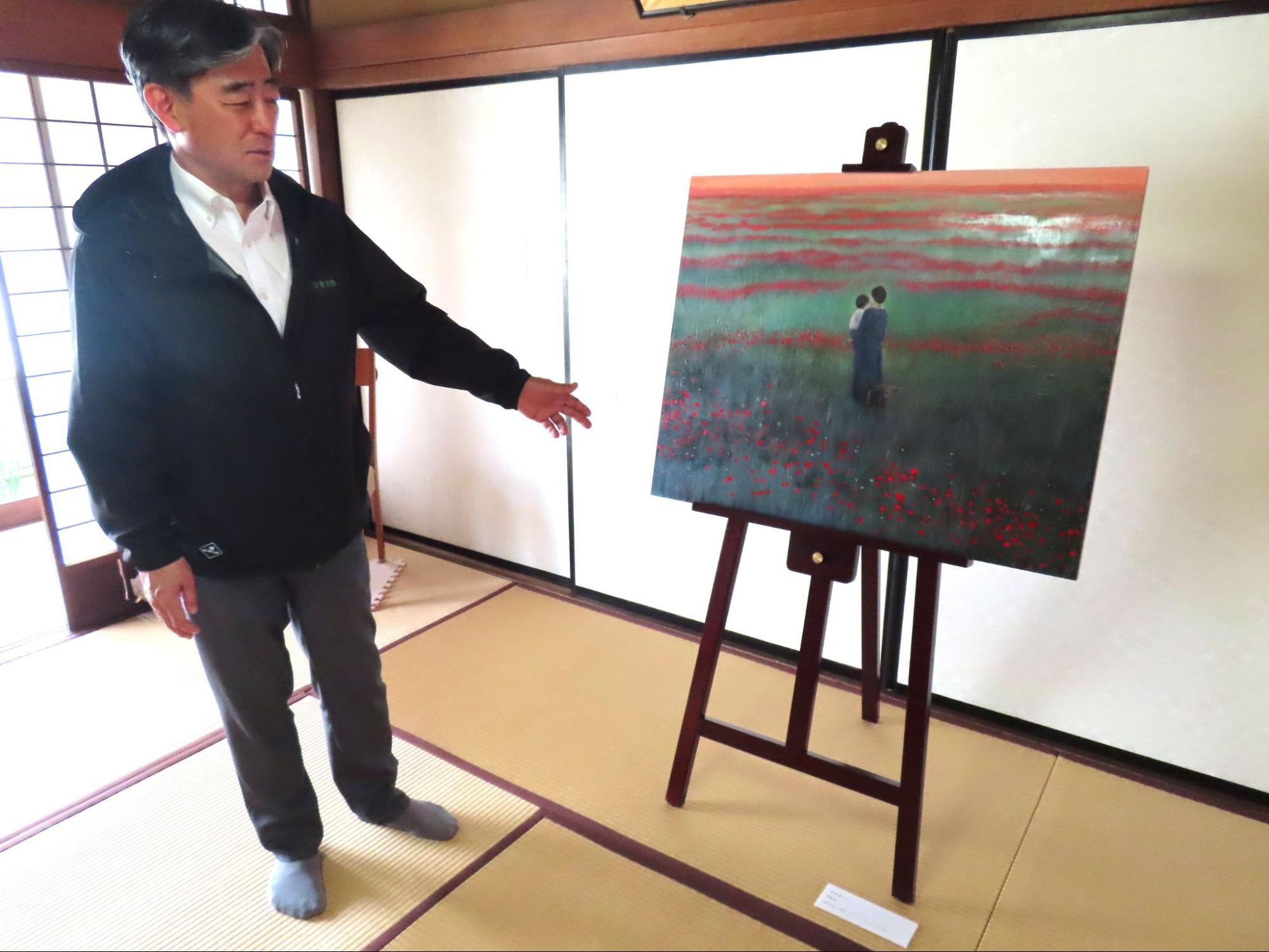 内田すずめさんの作品「プラネット」を解説する佐藤社長