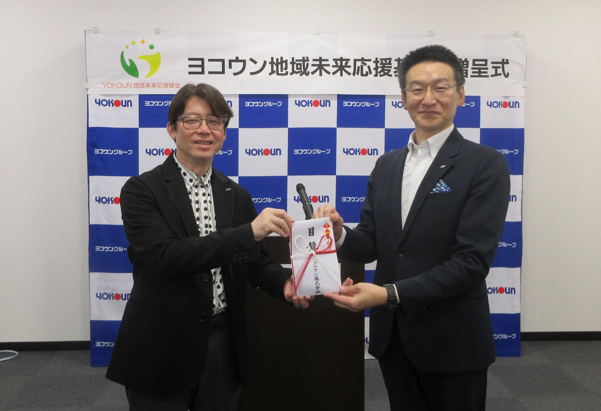 目録を手にする塩田社長㊧とあきた芸術村の今村社長