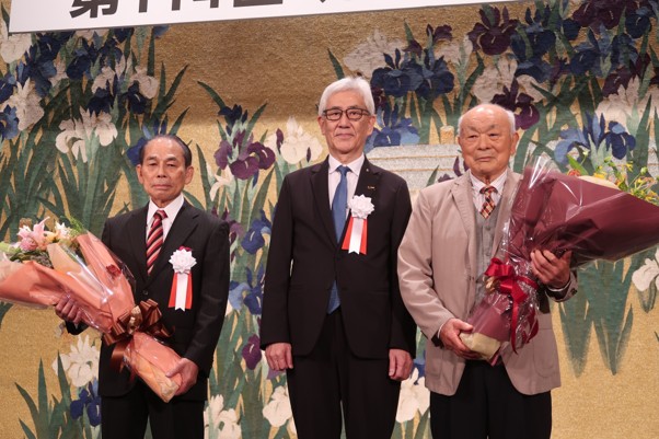 鴻池新会長（中央）と花束を持つ重会長代行（左隣）、池辺副会長