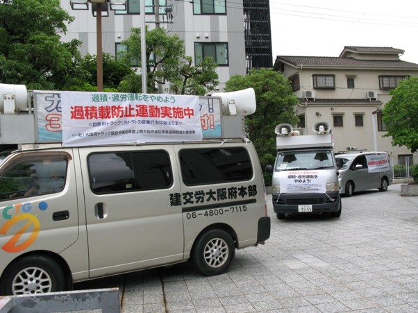 横断幕を付けた宣伝カーが出発