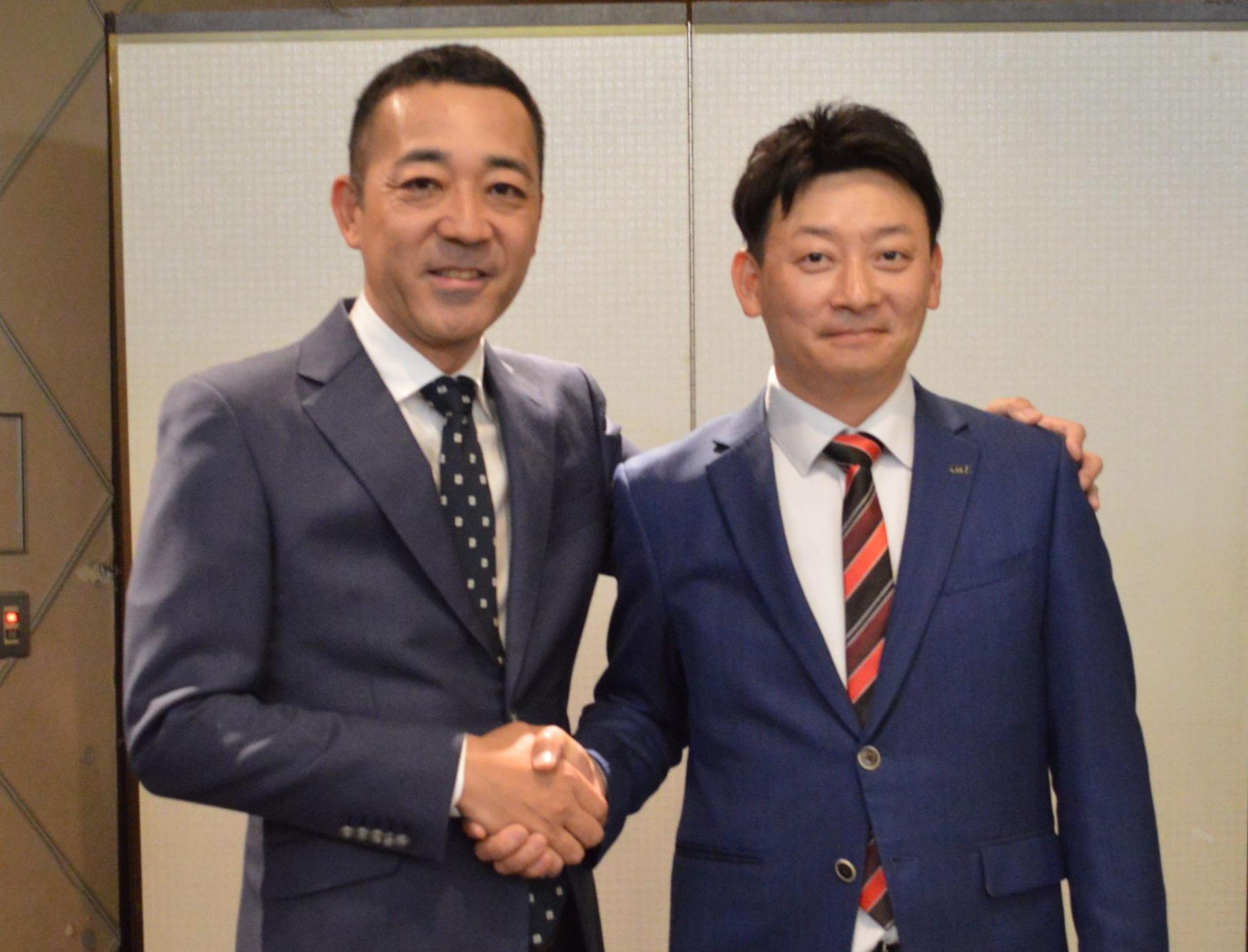 総会後に握手を交わす藤谷部会長㊧と金新部会長