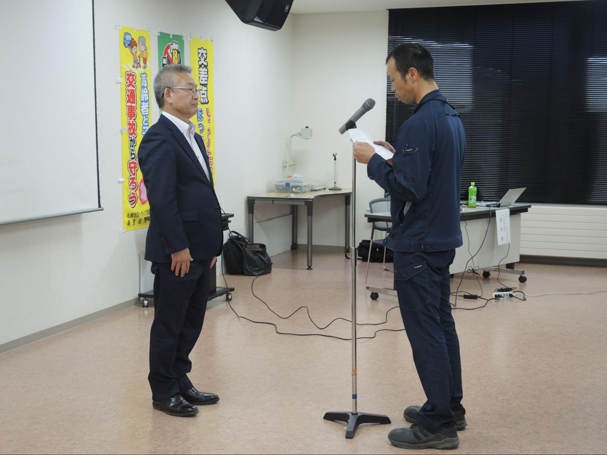 工藤支部長?に決意表明を行う日豊運輸のドライバーの加藤氏