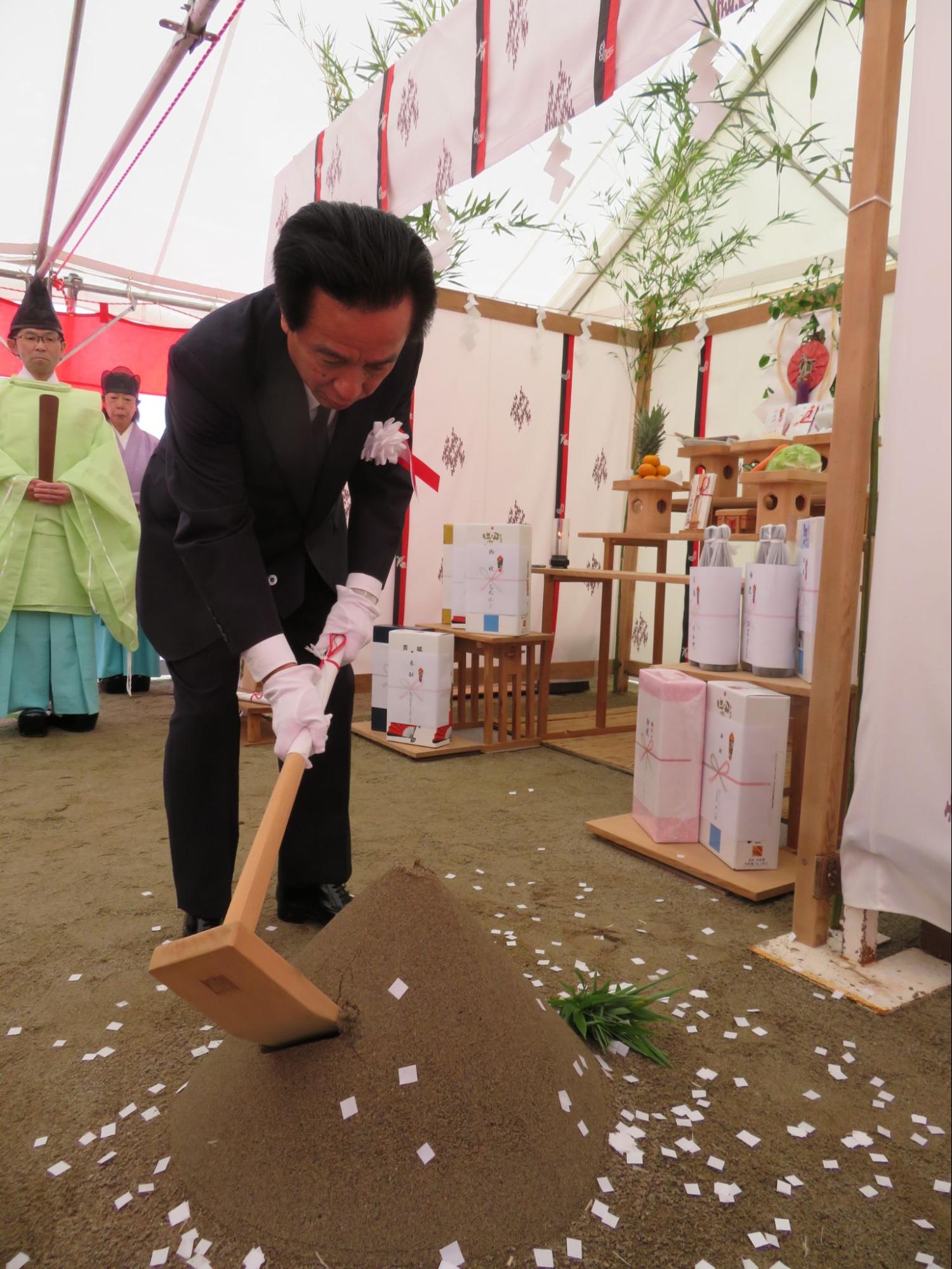 起工式でくわ入れの神事を行う早田社長