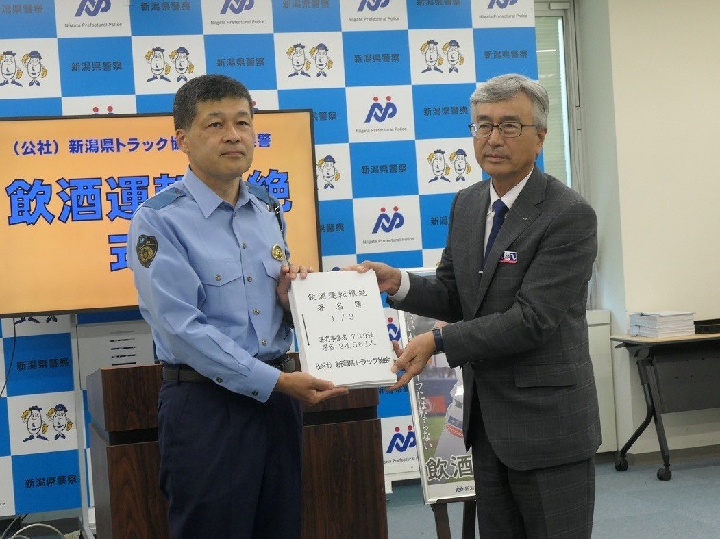 県警の山崎交通部長㊧へ名簿を手渡す坂井副会長<br>