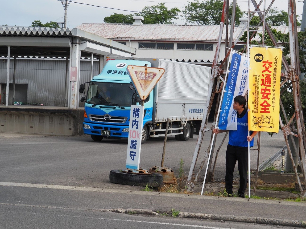 朝に会社の前の道路で啓発の旗を手に呼びかけ