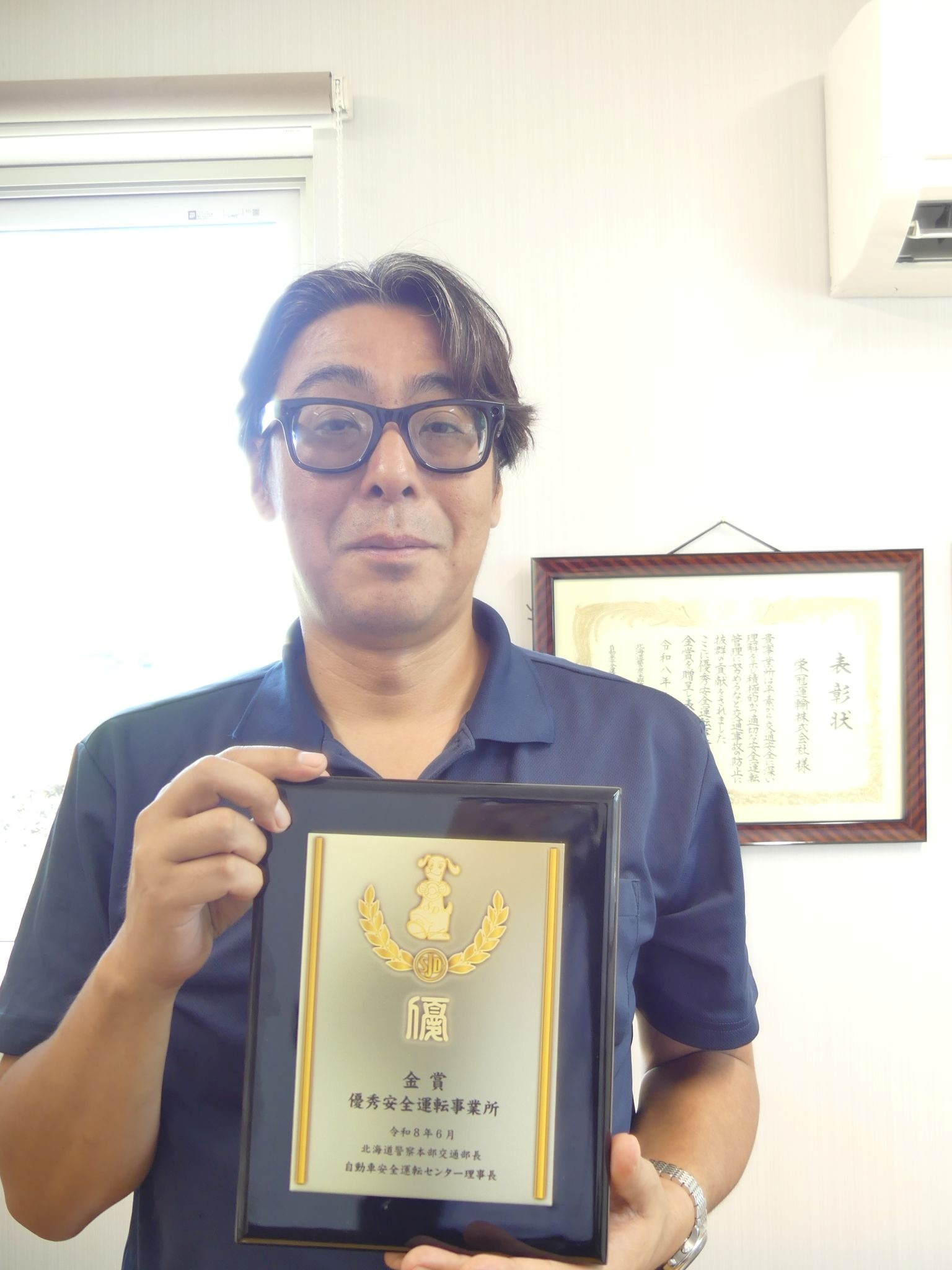 記念の盾を持つ伊藤社長