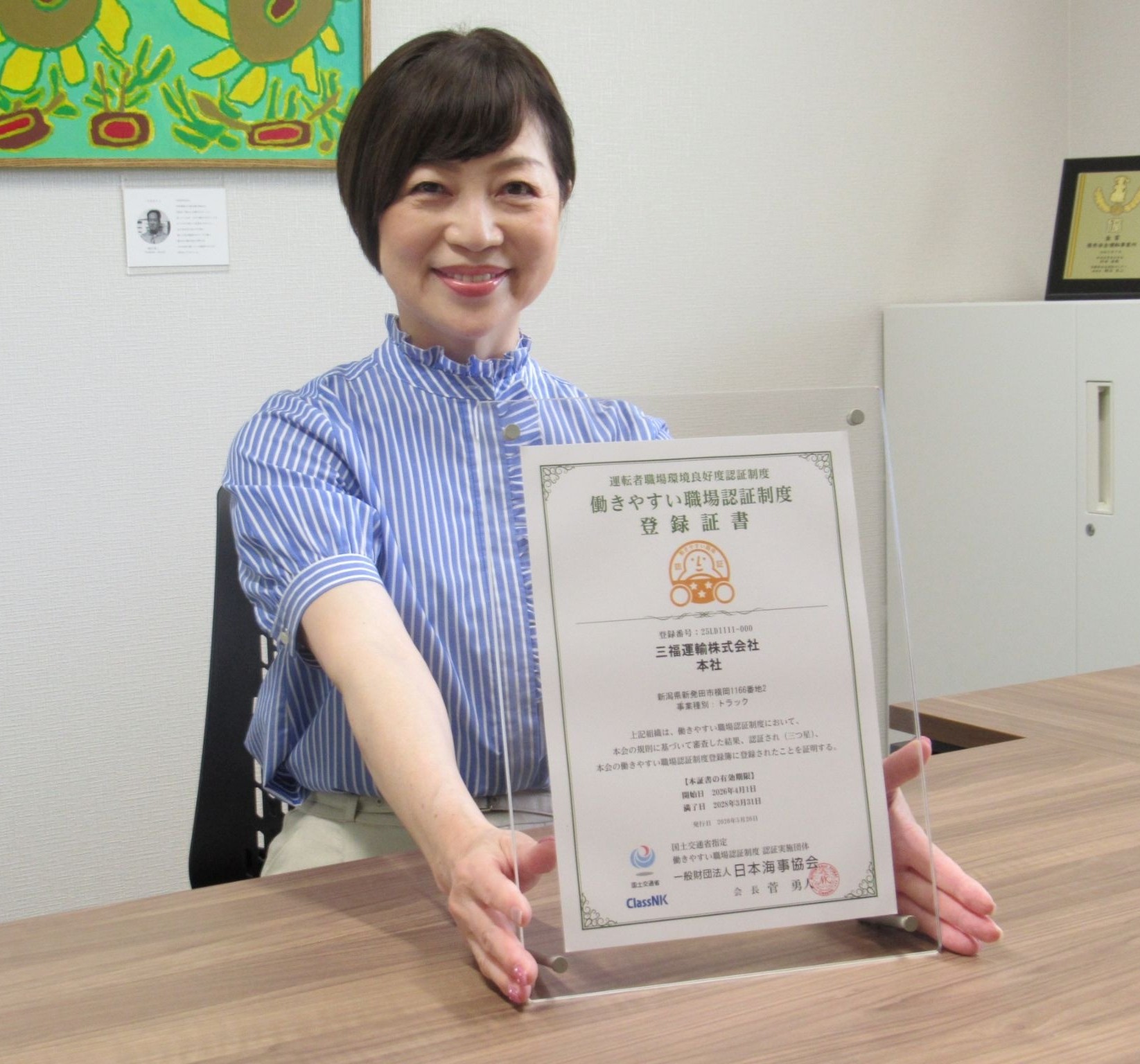 登録証書を持つ五月女社長