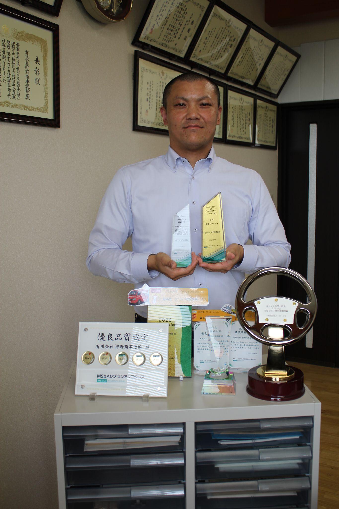 トロフィーを掲げる狩野社長