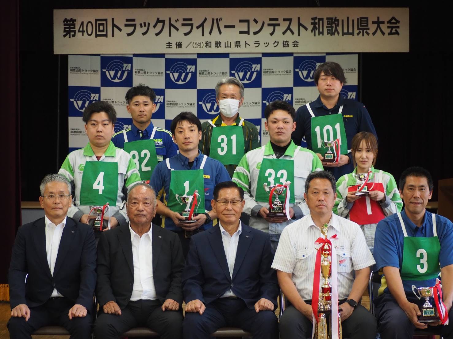 阪本会長（最前列中央）とトロフィーを手に上位入賞選手ら