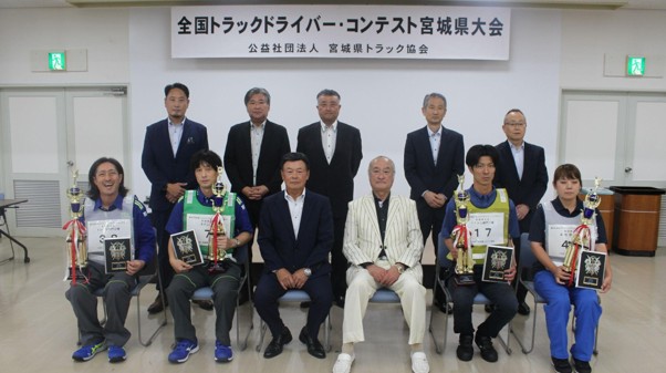 トロフィーと盾を手にする優勝者ら
