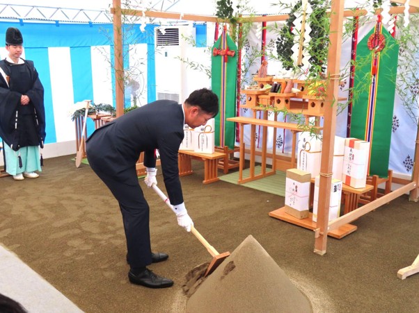 新センターの竣工を祈願し、力強くくわを入れる髙橋社長