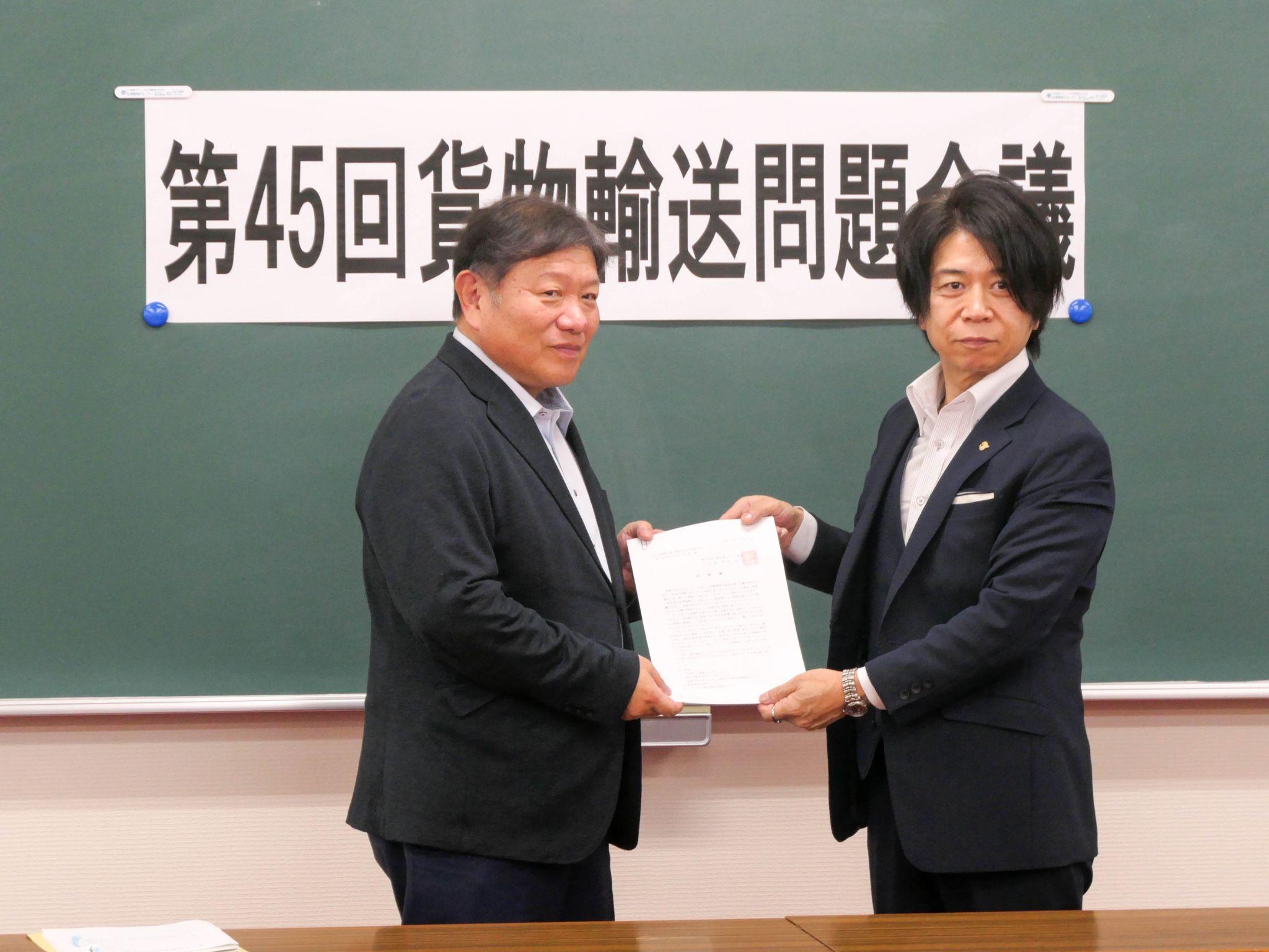 運輸労連栃木県連の田中執行委員長㊧に回答書を渡す栃ト協の半田会長<br>