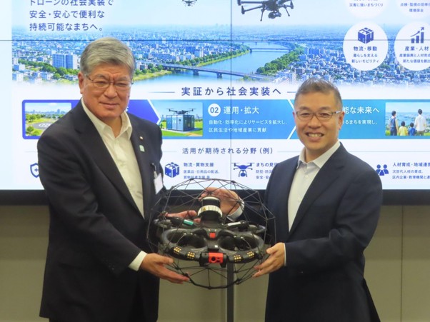 ドローンを手に坂本板橋区長㊧と熊田BI社長<br>