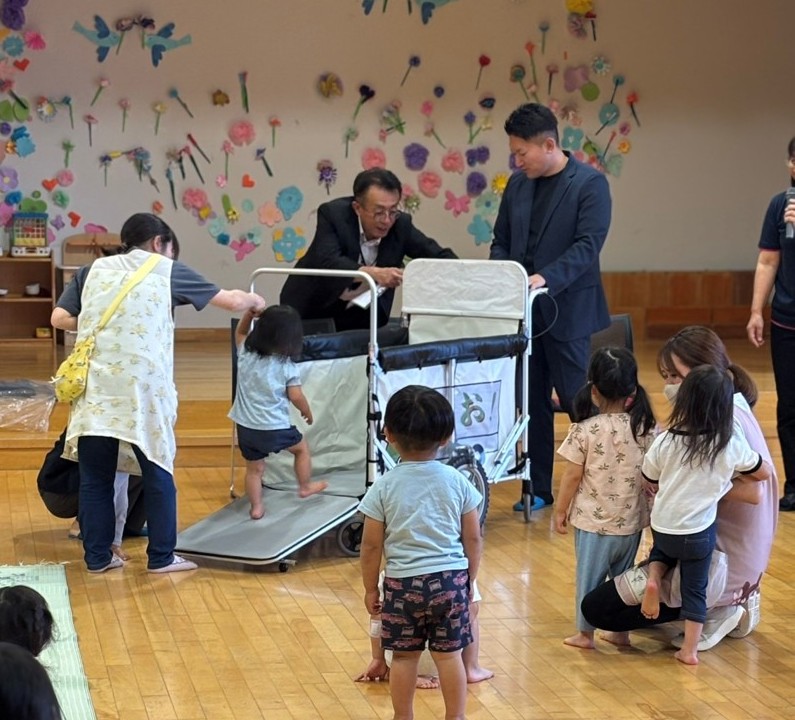山形村の保育園でカートを確認する中込保夫課長（奥左）と齋藤社長（右隣）＝6月12日
