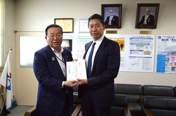 寄付金を手に菅井社長㊨と渥美市長