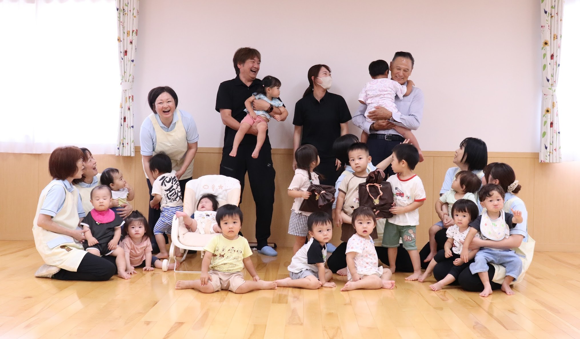 子どもたちと触れ合う滝澤社長（最後列右端）と保育士ら