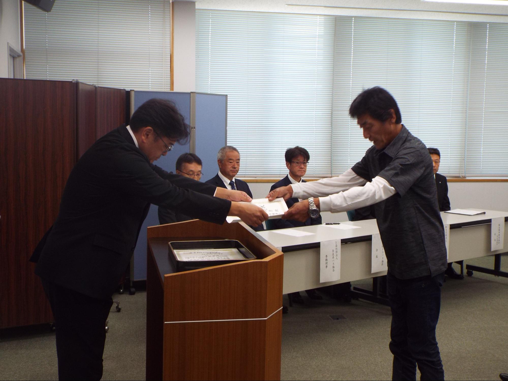 コタニ運輸の小谷氏㊨に表彰状を手渡す辻本支局長