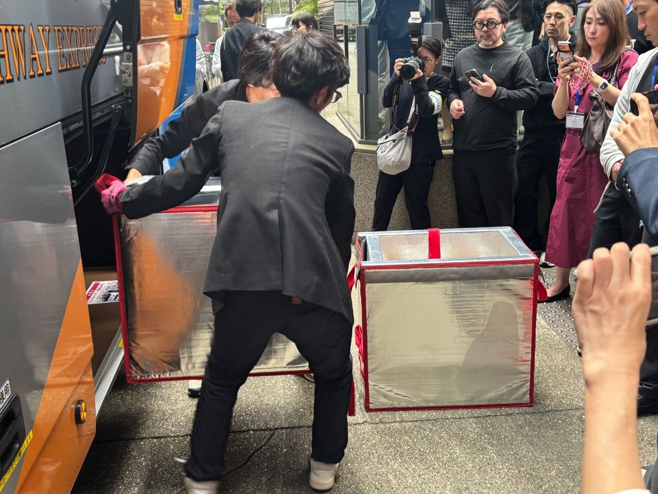 東京駅に到着した長距離バスのトランクルームから荷物を取り出す<br>